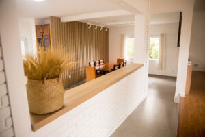 Elegância e Funcionalidade A sala de jantar é um dos ambientes mais importantes de qualquer casa. É onde compartilhamos refeições, celebramos ocasiões especiais e passamos momentos de qualidade com a família e amigos. Criar um espaço acolhedor e funcional nesse ambiente pode ser desafiador, mas com a ajuda de móveis planejados, é possível alcançar um equilíbrio perfeito entre elegância e praticidade. Aqui vamos compartilhar dicas sobre como escolher e dispor móveis planejados na sala de jantar para transformar esse espaço em um verdadeiro convite ao convívio. 1. A Escolha dos Móveis Planejados Mesa de Jantar: A mesa é o ponto central da sala de jantar. Ao escolher uma mesa planejada, considere o tamanho e a forma que melhor se adaptam ao espaço disponível. Mesas retangulares são ideais para ambientes mais longos e estreitos, enquanto mesas redondas ou ovais funcionam bem em espaços menores, facilitando a circulação. Cadeiras Confortáveis: Opte por cadeiras confortáveis e ergonômicas que complementem o design da mesa. Cadeiras estofadas com materiais duráveis são uma excelente escolha para garantir o conforto durante as refeições prolongadas. Buffet ou Aparador: Um buffet ou aparador planejado não só adiciona elegância à sala de jantar, mas também oferece espaço de armazenamento adicional para louças, talheres e utensílios. Escolha um modelo que harmonize com a mesa e as cadeiras, mantendo a coesão do design. 2. Distribuição dos Móveis Espaço de Circulação: Garanta que haja espaço suficiente para a circulação ao redor da mesa. Recomenda-se deixar, no mínimo, 90 cm de espaço livre entre a mesa e as paredes ou outros móveis, permitindo que as pessoas se movimentem confortavelmente. Harmonia e Proporção: Certifique-se de que os móveis estejam proporcionais ao tamanho da sala de jantar. Móveis muito grandes podem sobrecarregar o espaço, enquanto móveis muito pequenos podem fazer a sala parecer desordenada. Iluminação: A iluminação adequada é crucial para criar um ambiente acolhedor. Instale um pendente ou lustre centralizado sobre a mesa de jantar para destacar o ponto focal do ambiente. Luzes indiretas e abajures em buffets ou aparadores podem adicionar um toque extra de sofisticação. 3. Estilo e Personalização Cores e Acabamentos: Escolha cores e acabamentos que reflitam o seu estilo pessoal e complementem a decoração geral da casa. Tons neutros, como branco, cinza e madeira natural, são versáteis e atemporais, enquanto cores mais ousadas podem adicionar um toque de personalidade. Detalhes Decorativos: Incorpore detalhes decorativos, como arranjos de flores, velas e obras de arte, para adicionar charme e personalidade à sala de jantar. Utilize tapetes para delimitar a área da mesa e cadeiras, criando uma sensação de espaço definido. 4. Funcionalidade e Praticidade Armazenamento Inteligente: Móveis planejados permitem a inclusão de soluções de armazenamento inteligentes, como gavetas embutidas em buffets ou aparadores, prateleiras ajustáveis e compartimentos ocultos. Isso ajuda a manter a sala de jantar organizada e livre de desordem. Versatilidade: Considere a versatilidade dos móveis ao planejar a sala de jantar. Mesas extensíveis são ótimas para acomodar mais pessoas em ocasiões especiais, enquanto cadeiras empilháveis ou dobráveis podem ser guardadas quando não estiverem em uso. 5. Sustentabilidade e Durabilidade Materiais de Qualidade: Invista em materiais de alta qualidade que garantam a durabilidade dos móveis planejados. Madeira maciça, laminados resistentes e revestimentos fáceis de limpar são opções excelentes para a sala de jantar. Design Sustentável: Opte por móveis planejados com design sustentável, utilizando materiais ecologicamente corretos e processos de fabricação que minimizem o impacto ambiental. A Planejados Móveis Brasil está comprometida em ajudar você a criar a sala de jantar dos seus sonhos, combinando elegância e funcionalidade. Nossos móveis planejados são projetados para se adaptar perfeitamente ao seu espaço e estilo de vida, proporcionando um ambiente acolhedor e sofisticado para todos os seus momentos especiais. Entre em contato conosco e descubra como nossos especialistas podem transformar sua sala de jantar em um espaço convidativo e elegante.