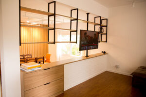 Elegância e Funcionalidade A sala de jantar é um dos ambientes mais importantes de qualquer casa. É onde compartilhamos refeições, celebramos ocasiões especiais e passamos momentos de qualidade com a família e amigos. Criar um espaço acolhedor e funcional nesse ambiente pode ser desafiador, mas com a ajuda de móveis planejados, é possível alcançar um equilíbrio perfeito entre elegância e praticidade. Aqui vamos compartilhar dicas sobre como escolher e dispor móveis planejados na sala de jantar para transformar esse espaço em um verdadeiro convite ao convívio. 1. A Escolha dos Móveis Planejados Mesa de Jantar: A mesa é o ponto central da sala de jantar. Ao escolher uma mesa planejada, considere o tamanho e a forma que melhor se adaptam ao espaço disponível. Mesas retangulares são ideais para ambientes mais longos e estreitos, enquanto mesas redondas ou ovais funcionam bem em espaços menores, facilitando a circulação. Cadeiras Confortáveis: Opte por cadeiras confortáveis e ergonômicas que complementem o design da mesa. Cadeiras estofadas com materiais duráveis são uma excelente escolha para garantir o conforto durante as refeições prolongadas. Buffet ou Aparador: Um buffet ou aparador planejado não só adiciona elegância à sala de jantar, mas também oferece espaço de armazenamento adicional para louças, talheres e utensílios. Escolha um modelo que harmonize com a mesa e as cadeiras, mantendo a coesão do design. 2. Distribuição dos Móveis Espaço de Circulação: Garanta que haja espaço suficiente para a circulação ao redor da mesa. Recomenda-se deixar, no mínimo, 90 cm de espaço livre entre a mesa e as paredes ou outros móveis, permitindo que as pessoas se movimentem confortavelmente. Harmonia e Proporção: Certifique-se de que os móveis estejam proporcionais ao tamanho da sala de jantar. Móveis muito grandes podem sobrecarregar o espaço, enquanto móveis muito pequenos podem fazer a sala parecer desordenada. Iluminação: A iluminação adequada é crucial para criar um ambiente acolhedor. Instale um pendente ou lustre centralizado sobre a mesa de jantar para destacar o ponto focal do ambiente. Luzes indiretas e abajures em buffets ou aparadores podem adicionar um toque extra de sofisticação. 3. Estilo e Personalização Cores e Acabamentos: Escolha cores e acabamentos que reflitam o seu estilo pessoal e complementem a decoração geral da casa. Tons neutros, como branco, cinza e madeira natural, são versáteis e atemporais, enquanto cores mais ousadas podem adicionar um toque de personalidade. Detalhes Decorativos: Incorpore detalhes decorativos, como arranjos de flores, velas e obras de arte, para adicionar charme e personalidade à sala de jantar. Utilize tapetes para delimitar a área da mesa e cadeiras, criando uma sensação de espaço definido. 4. Funcionalidade e Praticidade Armazenamento Inteligente: Móveis planejados permitem a inclusão de soluções de armazenamento inteligentes, como gavetas embutidas em buffets ou aparadores, prateleiras ajustáveis e compartimentos ocultos. Isso ajuda a manter a sala de jantar organizada e livre de desordem. Versatilidade: Considere a versatilidade dos móveis ao planejar a sala de jantar. Mesas extensíveis são ótimas para acomodar mais pessoas em ocasiões especiais, enquanto cadeiras empilháveis ou dobráveis podem ser guardadas quando não estiverem em uso. 5. Sustentabilidade e Durabilidade Materiais de Qualidade: Invista em materiais de alta qualidade que garantam a durabilidade dos móveis planejados. Madeira maciça, laminados resistentes e revestimentos fáceis de limpar são opções excelentes para a sala de jantar. Design Sustentável: Opte por móveis planejados com design sustentável, utilizando materiais ecologicamente corretos e processos de fabricação que minimizem o impacto ambiental. A Planejados Móveis Brasil está comprometida em ajudar você a criar a sala de jantar dos seus sonhos, combinando elegância e funcionalidade. Nossos móveis planejados são projetados para se adaptar perfeitamente ao seu espaço e estilo de vida, proporcionando um ambiente acolhedor e sofisticado para todos os seus momentos especiais. Entre em contato conosco e descubra como nossos especialistas podem transformar sua sala de jantar em um espaço convidativo e elegante.