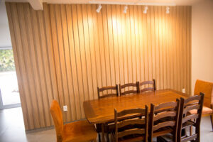 Elegância e Funcionalidade A sala de jantar é um dos ambientes mais importantes de qualquer casa. É onde compartilhamos refeições, celebramos ocasiões especiais e passamos momentos de qualidade com a família e amigos. Criar um espaço acolhedor e funcional nesse ambiente pode ser desafiador, mas com a ajuda de móveis planejados, é possível alcançar um equilíbrio perfeito entre elegância e praticidade. Aqui vamos compartilhar dicas sobre como escolher e dispor móveis planejados na sala de jantar para transformar esse espaço em um verdadeiro convite ao convívio. 1. A Escolha dos Móveis Planejados Mesa de Jantar: A mesa é o ponto central da sala de jantar. Ao escolher uma mesa planejada, considere o tamanho e a forma que melhor se adaptam ao espaço disponível. Mesas retangulares são ideais para ambientes mais longos e estreitos, enquanto mesas redondas ou ovais funcionam bem em espaços menores, facilitando a circulação. Cadeiras Confortáveis: Opte por cadeiras confortáveis e ergonômicas que complementem o design da mesa. Cadeiras estofadas com materiais duráveis são uma excelente escolha para garantir o conforto durante as refeições prolongadas. Buffet ou Aparador: Um buffet ou aparador planejado não só adiciona elegância à sala de jantar, mas também oferece espaço de armazenamento adicional para louças, talheres e utensílios. Escolha um modelo que harmonize com a mesa e as cadeiras, mantendo a coesão do design. 2. Distribuição dos Móveis Espaço de Circulação: Garanta que haja espaço suficiente para a circulação ao redor da mesa. Recomenda-se deixar, no mínimo, 90 cm de espaço livre entre a mesa e as paredes ou outros móveis, permitindo que as pessoas se movimentem confortavelmente. Harmonia e Proporção: Certifique-se de que os móveis estejam proporcionais ao tamanho da sala de jantar. Móveis muito grandes podem sobrecarregar o espaço, enquanto móveis muito pequenos podem fazer a sala parecer desordenada. Iluminação: A iluminação adequada é crucial para criar um ambiente acolhedor. Instale um pendente ou lustre centralizado sobre a mesa de jantar para destacar o ponto focal do ambiente. Luzes indiretas e abajures em buffets ou aparadores podem adicionar um toque extra de sofisticação. 3. Estilo e Personalização Cores e Acabamentos: Escolha cores e acabamentos que reflitam o seu estilo pessoal e complementem a decoração geral da casa. Tons neutros, como branco, cinza e madeira natural, são versáteis e atemporais, enquanto cores mais ousadas podem adicionar um toque de personalidade. Detalhes Decorativos: Incorpore detalhes decorativos, como arranjos de flores, velas e obras de arte, para adicionar charme e personalidade à sala de jantar. Utilize tapetes para delimitar a área da mesa e cadeiras, criando uma sensação de espaço definido. 4. Funcionalidade e Praticidade Armazenamento Inteligente: Móveis planejados permitem a inclusão de soluções de armazenamento inteligentes, como gavetas embutidas em buffets ou aparadores, prateleiras ajustáveis e compartimentos ocultos. Isso ajuda a manter a sala de jantar organizada e livre de desordem. Versatilidade: Considere a versatilidade dos móveis ao planejar a sala de jantar. Mesas extensíveis são ótimas para acomodar mais pessoas em ocasiões especiais, enquanto cadeiras empilháveis ou dobráveis podem ser guardadas quando não estiverem em uso. 5. Sustentabilidade e Durabilidade Materiais de Qualidade: Invista em materiais de alta qualidade que garantam a durabilidade dos móveis planejados. Madeira maciça, laminados resistentes e revestimentos fáceis de limpar são opções excelentes para a sala de jantar. Design Sustentável: Opte por móveis planejados com design sustentável, utilizando materiais ecologicamente corretos e processos de fabricação que minimizem o impacto ambiental. A Planejados Móveis Brasil está comprometida em ajudar você a criar a sala de jantar dos seus sonhos, combinando elegância e funcionalidade. Nossos móveis planejados são projetados para se adaptar perfeitamente ao seu espaço e estilo de vida, proporcionando um ambiente acolhedor e sofisticado para todos os seus momentos especiais. Entre em contato conosco e descubra como nossos especialistas podem transformar sua sala de jantar em um espaço convidativo e elegante.